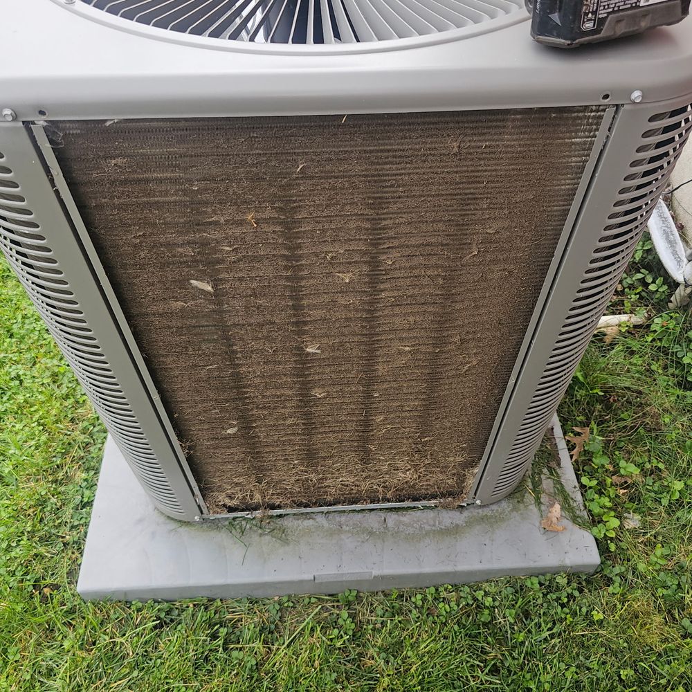 Air conditioning condenser coil packed with grass and dirt before cleaning
