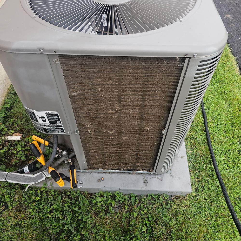Air conditioning condenser coil packed with grass and dirt before cleaning
